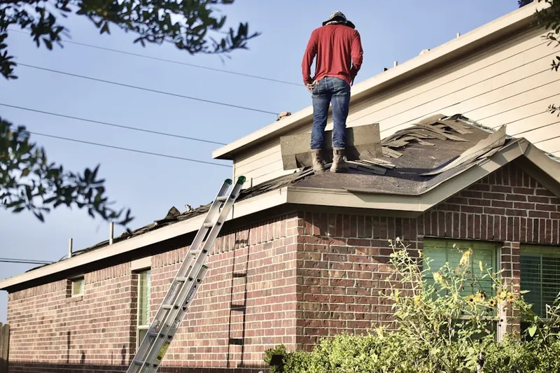 Professional roofer working on a residential roof in Piscataquog